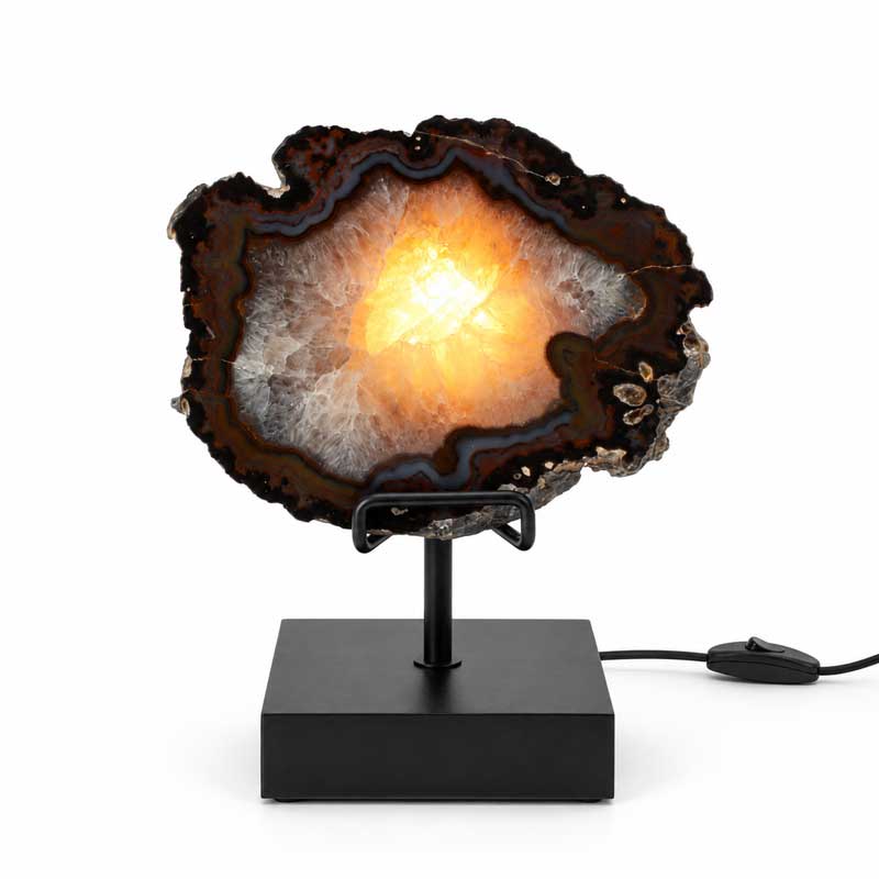 Agaat lamp Nova met zwarte standaard, donkere agaatrand en warm verlicht kristalcentrum