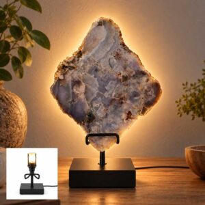 Roze Amethist Halo lamp op zwarte standaard met warme gloed tegen witte achtergrond