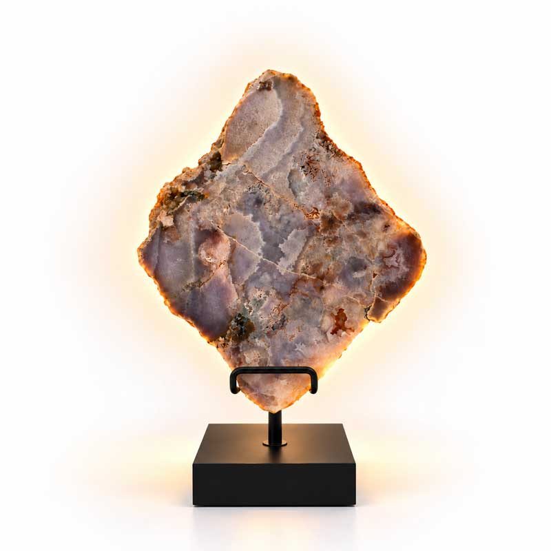 Roze Amethist Halo lamp op zwarte standaard met warme gloed tegen witte achtergrond