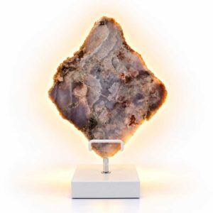 Roze Amethist Halo lamp op witte standaard met warme gloed langs de natuurlijke steenranden