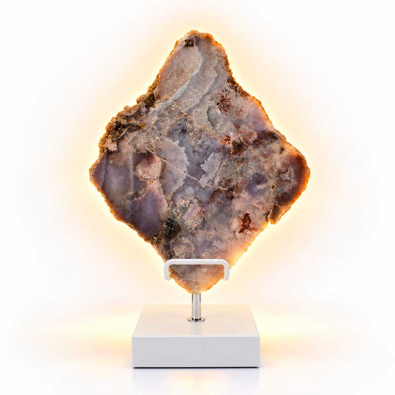 Roze Amethist Halo lamp op witte standaard met warme gloed langs de natuurlijke steenranden