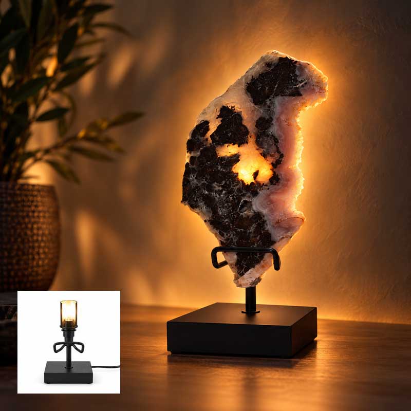 Roze Amethist Eclipse lamp op zwarte standaard met warme achterverlichting in sfeervol interieur