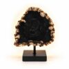 Versteend Hout Lamp Eclipse met donker hart en warme gloed op zwarte standaard