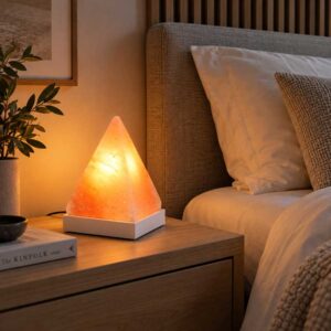 Zoutlamp Peak met piramidevormige zoutsteen op witte voet in sfeervolle slaapkamer