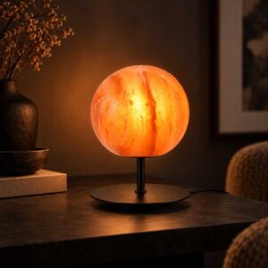 Zoutlamp Solis met ronde zoutsteen op zwarte standaard in sfeervol interieur