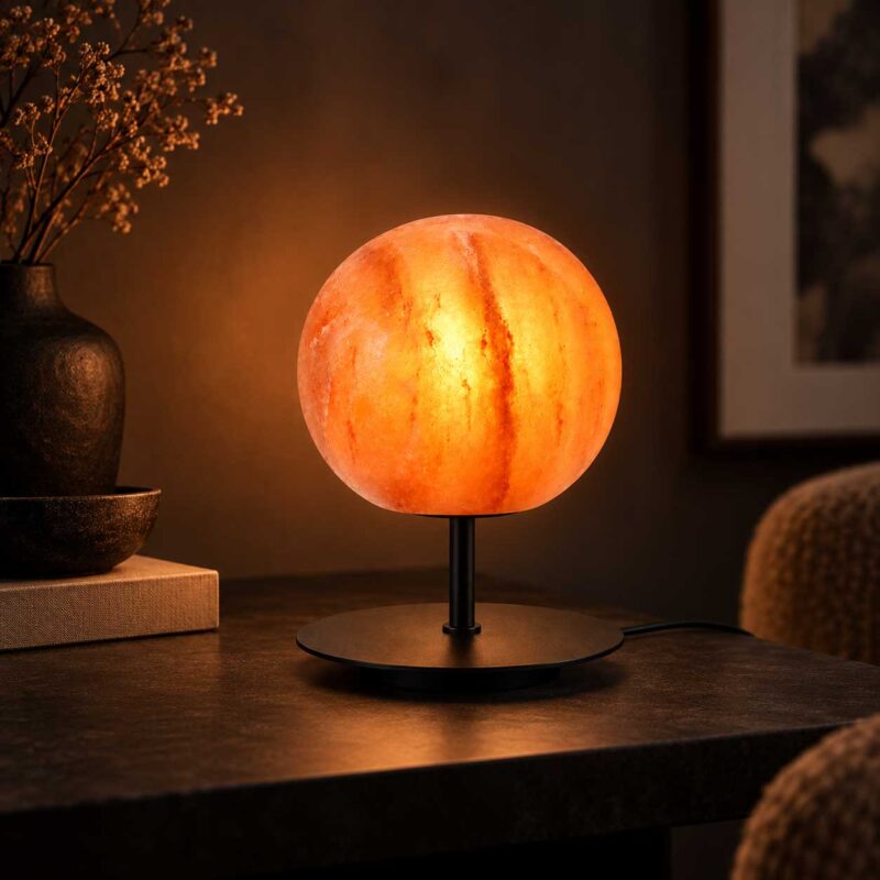 Zoutlamp Solis met ronde zoutsteen op zwarte standaard in sfeervol interieur