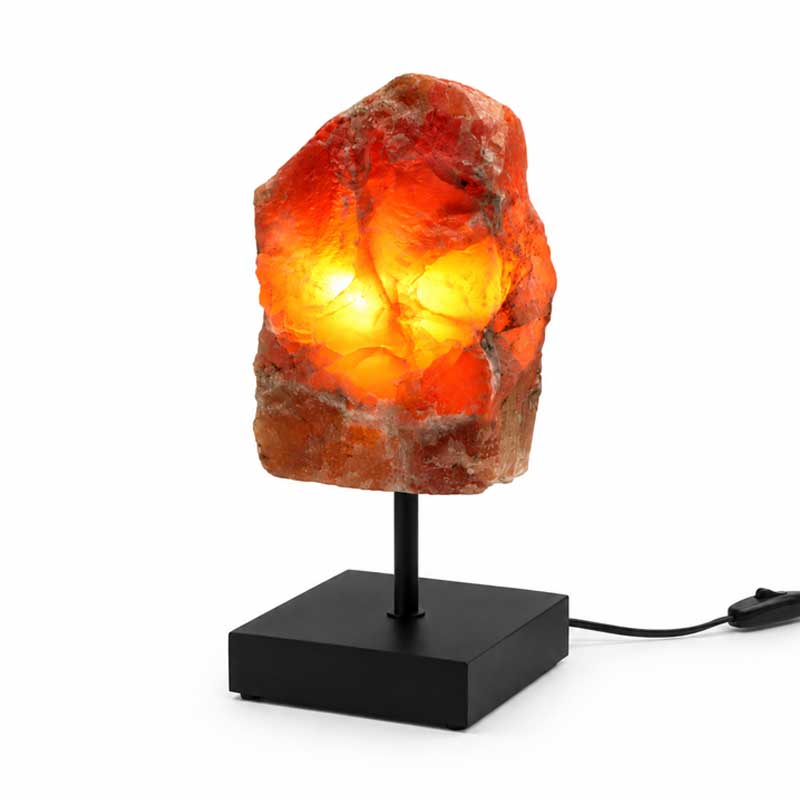 Aragoniet edelsteen lamp Amber Glow met warme oranje gloed op zwarte standaard