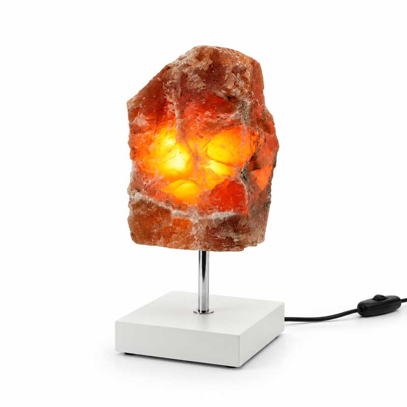 Aragoniet edelsteen lamp Amber Glow met warme oranje gloed op witte standaard