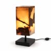 Onyx Edelsteen Lamp Firestone met warme amberkleurige verlichting, donkere natuurlijke aders en zwarte metalen standaard.