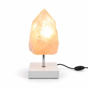 Rozenkwarts Rose Flame mineraallamp met witte vierkante voet, chromen standaard en warme verlichting in een natuurlijke kristalpunt.